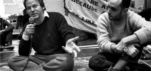 David Graeber sit with a mic